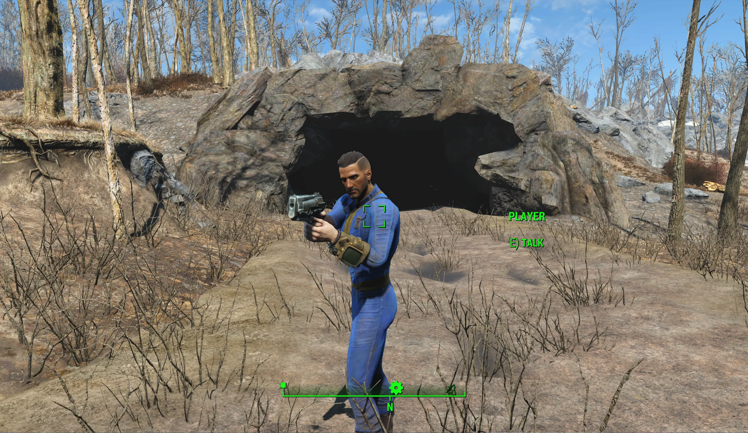 Remote player holding a 10mm pistol in front of a cave entrance